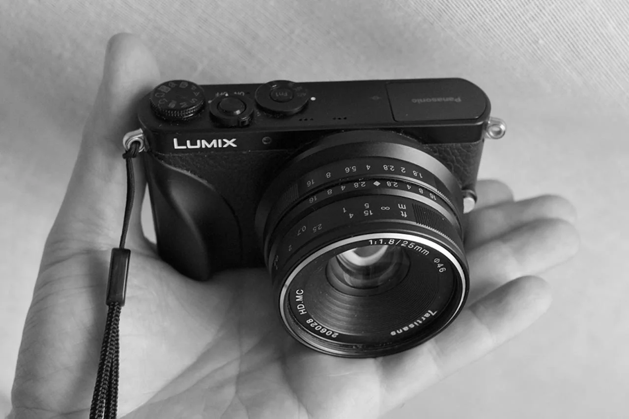 Håndholdt Panasonic Lumix-kamera med manuelt objektiv i svart-hvitt